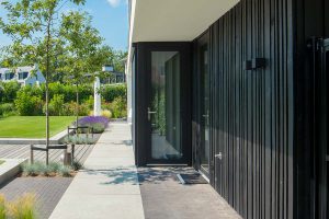 Zwarte-houten-garagedeur-verticaal-geprofileerd-in-drie-breedtes-gelijk-met-gevel-3