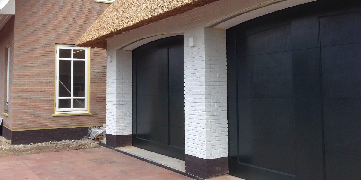 https://garagedeuren2.s3.eu-central-1.amazonaws.com/20180918104713/Twee-houten-garagedeuren-bij-rieten-kap-woning.jpg