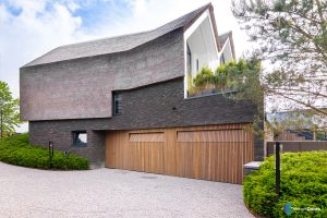 afbeelding Houten garagedeuren geïntegreerd in de gevel