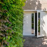 Witte houten openslaande garagedeuren met glas
