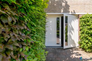 Witte houten openslaande garagedeuren met glas