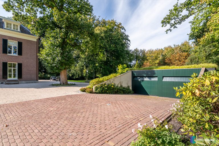 Houten sectionaaldeur gelijk met de gevel groen